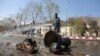 Afghan firefighters clean up the site of a deadly suicide bombing near Kabul University, in Kabul, March 21, 2018. 