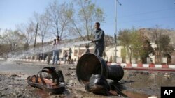 Afghan firefighters clean up the site of a deadly suicide bombing near Kabul University, in Kabul, March 21, 2018. 