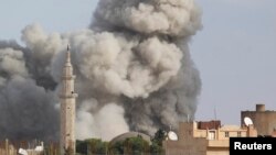 Smoke rises over the Syrian town of Ras al-Ain after an air strike November 13, 2012.