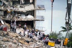 Rescue workers search in the rubble at the Champlain Towers South condominium, Monday, June 28, 2021, in the Surfside area of Miami.