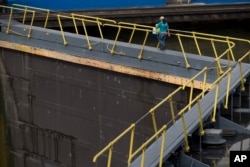 A worker walks across the Miraflores Locks during a press tour of the Panama Canal in Panama City, June 25, 2016. The $5.25 billion expansion of the canal will allow larger ships to pass, increasing efficiency.