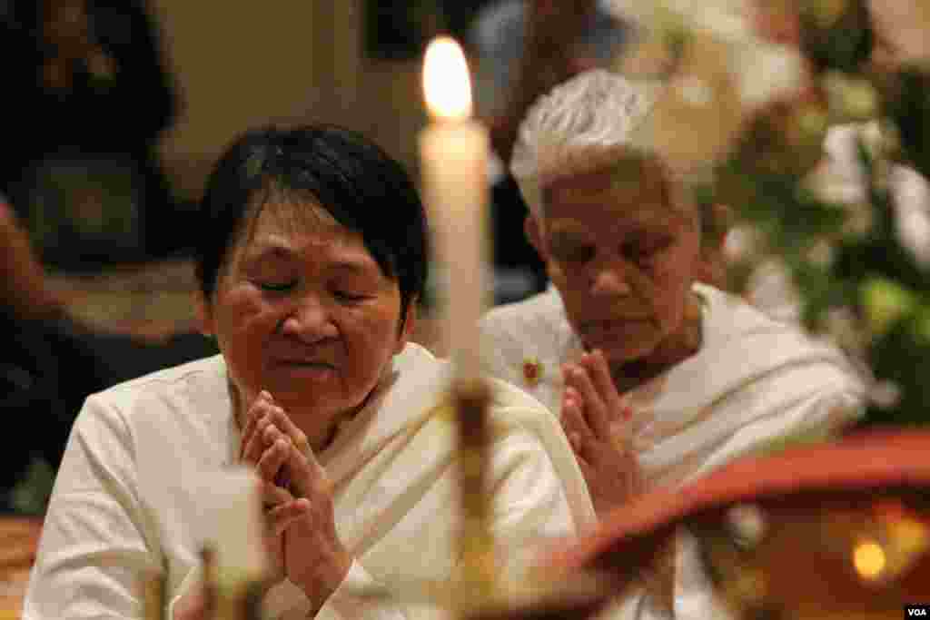 Two Cambodian buddhists pay a moment of silence Khmer Rouge victims at a memorial service at the Wat Buddhikaram Cambodian Buddhist temple in Silver Spring, Maryland, to mark the 40th anniversary of the takeover of the Khmer Rouge, on Friday, April 17, 2015.