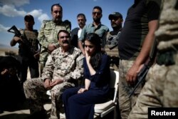 FILE - Yazidi survivor and U.N. Goodwill Ambassador for the Dignity of Survivors of Human trafficking Nadia Murad, center, visits her village for the first time after being captured and sold as a slave by the Islamic State three years ago, in Kojo, Iraq, June 1, 2017.