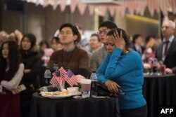 People watch a screen showing coverage of the US presidential election at an election event organized by the US Embassy, at a hotel in Seoul, Nov. 9, 2016.
