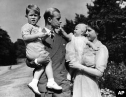 FILE - In this August 1951 file photo, then-Princess Elizabeth stands with her husband Prince Philip, the Duke of Edinburgh, and their children Prince Charles and Princess Anne at the couple's London residence at Clarence House.