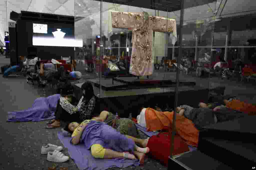 Passengers sleep in an airport terminal after typhoon Typhoon Vicente stopped flights out of the airport in Hong Kong, July 24, 2012.
