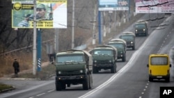 Unmarked military vehicles travel along a road outside the separatist rebel-held town Makiivka, 25 km (16 miles) from Donetsk, eastern Ukraine, Nov. 8, 2014