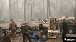 加州警察在天堂镇遭受山火施虐后抬走死难者的遗体。（2018年11月10日）