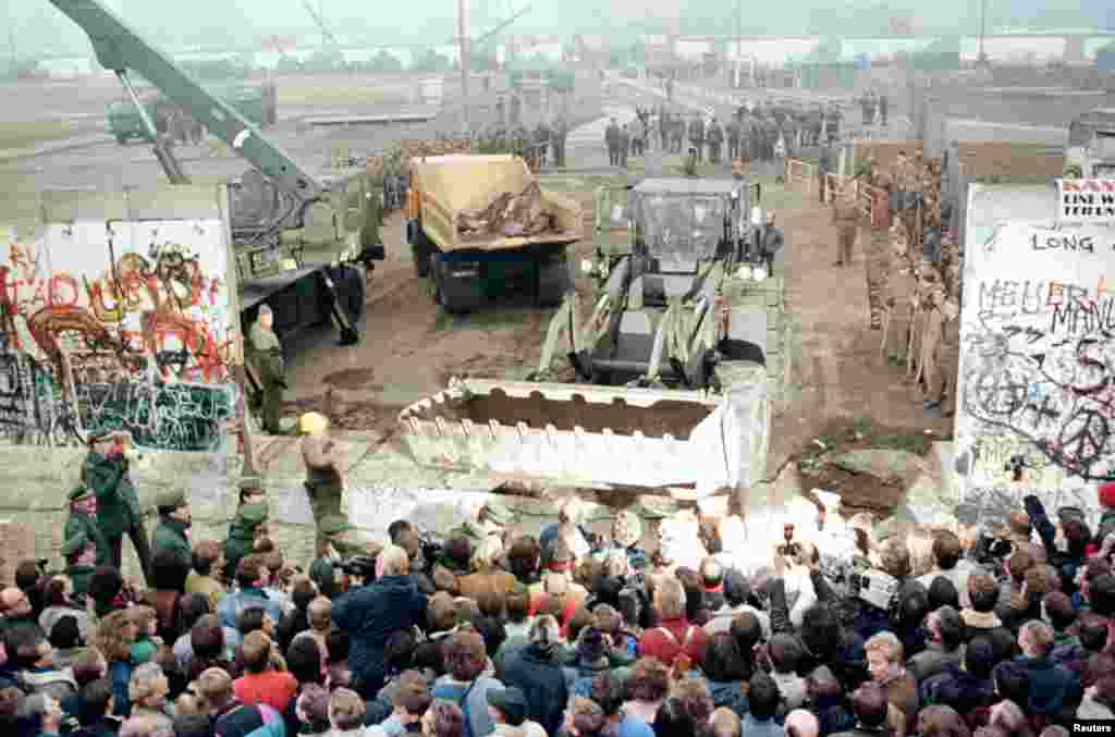 12 نومبر 1989 کو لی گئی ایک تصویر جس میں مشرقی جرمنی کے زیر استعمال رہنے والا ایک بلڈوزر اور کرین برلن وال کو مسمار کرتے ہوئے دیکھا جاسکتا ہے۔ 