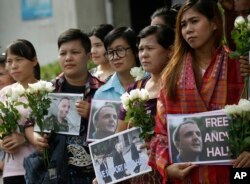 Pendukung memegang bunga dan dan plakat saat aktivis hak buruh Inggris, Andy Hall, tiba di Pengadilan Pidana, Bangkok, Thailand, Selasa, 20 September 2016. (Foto: dok).