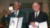 FILE - Then-South African Deputy President F.W. de Klerk, right, and South African President Nelson Mandela pose with their Nobel Peace Prize Gold Medals and Diplomas, in Oslo, Dec. 10, 1993.