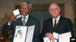 FILE - Then-South African Deputy President F.W. de Klerk, right, and South African President Nelson Mandela pose with their Nobel Peace Prize Gold Medals and Diplomas, in Oslo, Dec. 10, 1993.