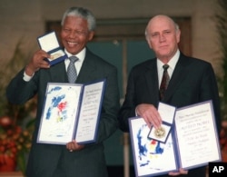 FILE - Then-South African Deputy President F.W. de Klerk, right, and then-South African President Nelson Mandela pose with their Nobel Peace Prize Gold Medal and Diploma, in Oslo, Dec. 10, 1993.