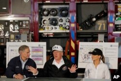 FILE - President Donald Trump, flanked by Texas Gov. Greg Abbott and first lady Melania Trump, speaks during a briefing on Harvey relief efforts at Firehouse 5 in Corpus Christi, Texas, Aug. 29, 2017.