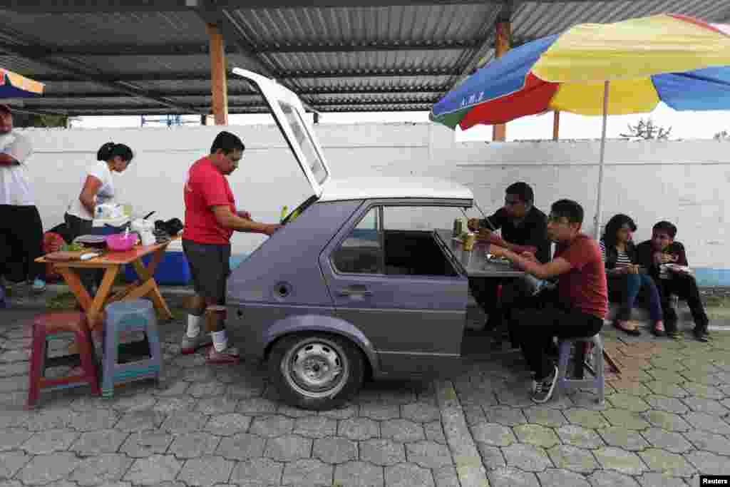 People have breakfast near a polling station in Mixco, Guatemala, Oct. 25, 2015. Playing up his outsider status and promising a clean government, 46-year-old Jimmy Morales, a former TV comedian, swept to power in the presidential election after milking public anger over a corruption scandal that deepened distrust of the political establishment.