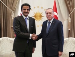 Turkey's President Recep Tayyip Erdogan, right, and Qatar's Emir Sheikh Tamim bin Hamad Al Thani shake hands before their talks in Ankara, Aug. 15, 2018.