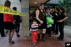 People who were near a shooting rampage that killed multiple people at a social services center, Dec. 2, 2015, leave a community center after they reunited with friends and family in San Bernardino, Calif.