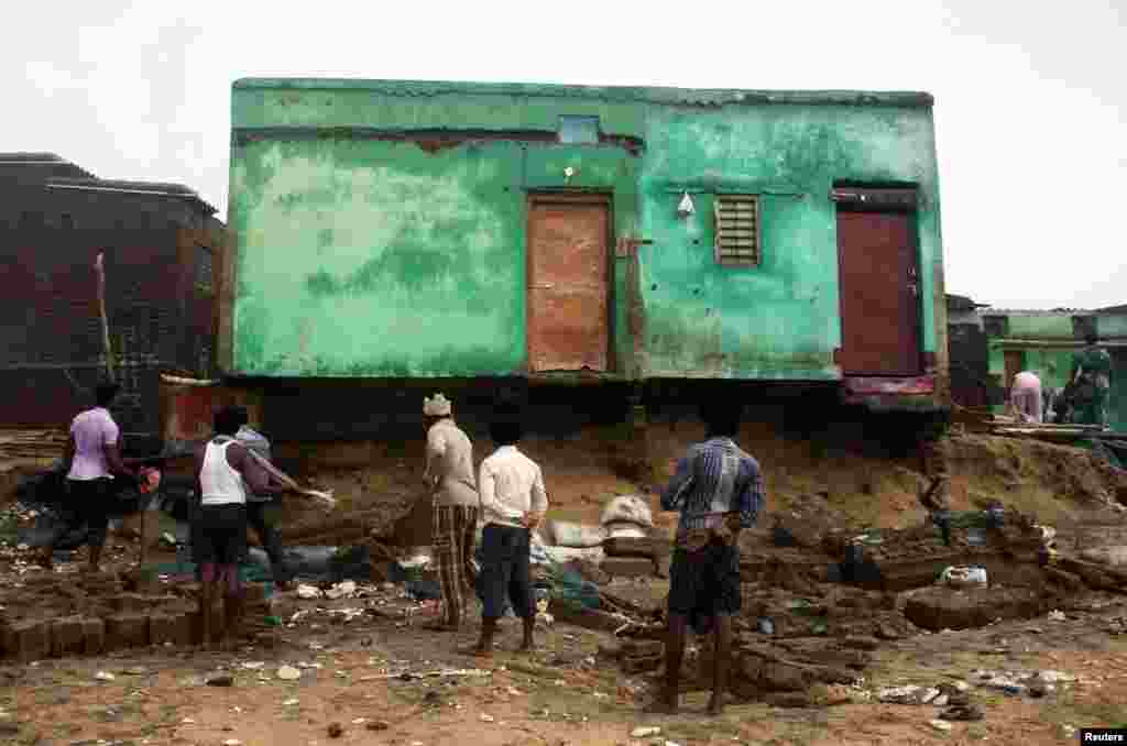 Fishermen clear debris from their damaged houses after Cyclone Phailin hit Puri in the eastern Indian state of Odisha, Oct. 14, 2013.