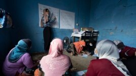 A volunteer teacher gives a basic English lesson to a minority Muslim Rohingya refugees at a slum on the outskirts of Kuala Lumpur, Malaysia, on Oct. 11, 2020.