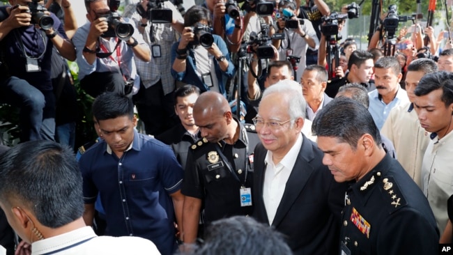 马来西亚前总理纳吉布（中）前往马来西亚反腐委员会接受跟“一马基金”公款案相关调查。（2018年5月24日）