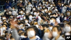 Baseball fans cheer their teams during a game between Kiwoom Heroes and Doosan Bears in Seoul, South Korea, Nov. 1, 2021. 