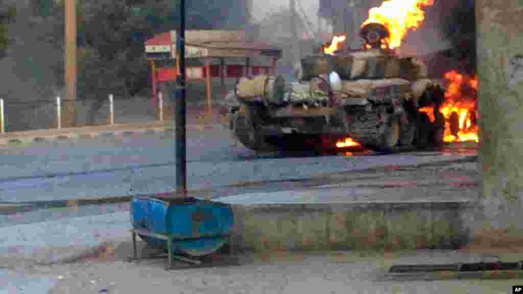 This citizen journalism image provided by The Syrian Revolution against Bashar Assad shows a Syrian military tank on fire during clashes in Joubar outside Damascus, Sept. 4, 2013.