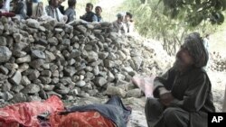 An Afghan man mourns the death of relatives near the site of the earthquake that hit Baghlan province, Afghanistan, June 11, 2012. 