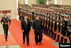 中国国家主席习近平在北京人民大会堂的欢迎仪式上同朝鲜国务委员会委员长金正恩检阅礼兵。（朝鲜官媒朝中社2018年3月28日对路透社发布的照片）。