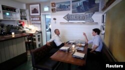 Canada's Prime Minister Justin Trudeau speaks with former United States President Barack Obama at a restaurant during Obama's visit to address the Montreal Chamber of Commerce, in Montreal, Quebec, June 5, 2017. 