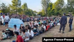 This photo taken on Dec. 16, 2021 by Metta Charity, shows people from Myanmar who fled a surge in violence sitting in lines as they are processed in Mae Tao Phae. in Thailand's Mae Sot district.