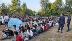 This photo taken on Dec. 16, 2021 by Metta Charity, shows people from Myanmar who fled a surge in violence sitting in lines as they are processed in Mae Tao Phae. in Thailand's Mae Sot district.