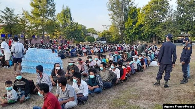 This photo taken on Dec. 16, 2021 by Metta Charity, shows people from Myanmar who fled a surge in violence sitting in lines as they are processed in Mae Tao Phae. in Thailand's Mae Sot district.