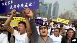 失踪马航班机中国乘客的亲属举着标语牌游行走向马来西亚驻北京大使馆（2014年3月25日）