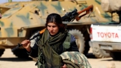 A female Kurdish fighter of the U.S.-backed Syrian Democratic Forces (SDF), made up of an alliance of Arab and Kurdish fighters, walks carrying a weapon in the village of Sabah al-Khayr on the northern outskirts of Deir Ezzor, February 21, 2017. (AFP)