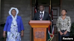 Kenya's Deputy President William Ruto (C) flanked by his wife Rachel Ruto (R) and mother Sarah Cherono (L) addresses a news conference on the ruling by the International Criminal Court (ICC) on the case against him and broadcaster Joshua Sang in Nairobi, 