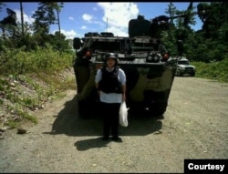 Linda Gurning, istri mendiang Harry Siregar, yang datang menabur bunga di Mil 37, TImika, Papua, dengan pengawalan ketat karena rentannya situasi keamanan. (Foto: pribadi)