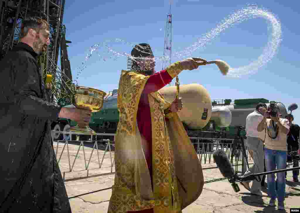 An Orthodox Priest blesses members of the media shortly after having blessed the Soyuz rocket at the Baikonur Cosmodrome Launch pad in Kazakhstan. 