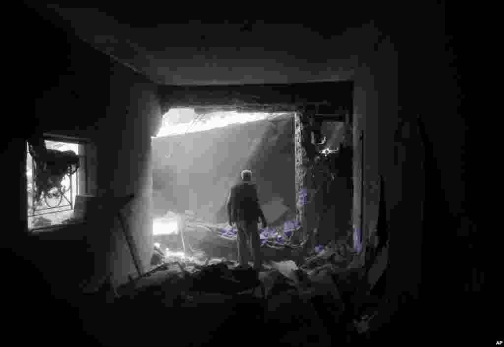 Član porodice Šabat na mestu svoje kuće porušene tokom izraelskih vazdušnih napada na mesto Beit Hanun u severnom delu Pojasa Gaze.
