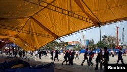 Bảo vệ và công nhân tháo dỡ các căn lều tại 1 khu trại bị người biểu tình chống chính phủ chiếm đóng ở Phnom Penh, 4/1/2014