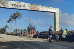 Masyarakat membersihkan puing-puing dari jalan di Nuku'alofa, Tonga, Kamis, 20 Januari 2022, pasca letusan gunung berapi di dekat kepulauan Pasifik, Sabtu (15/1) lalu. (Broadcom Broadcasting via AP)