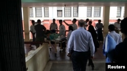 Perawat di rumah sakit umum Rangoon membawa seorang korban yang terluka akibat ledakan bom di Hotel Traders, Burma, 15/10/ 2013.