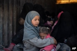 Children ride in the back of a truck that is part of a convoy evacuating hundreds out of the last territory held by Islamic State militants, in Baghouz, eastern Syria, Feb. 20, 2019.