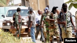 FILE - Mutinous soldiers arrive to speak with Ivory Coast's Minister of Defense Alain-Richard Donwahi in Bouake, Ivory Coast, Jan. 7, 2017. 