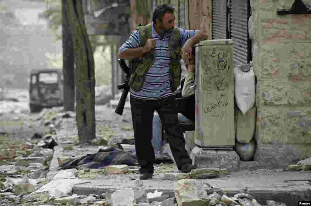 A Free Syrian Army fighter smokes a cigarette as he guards his position in Aleppo, Syria, October 23, 2012. 