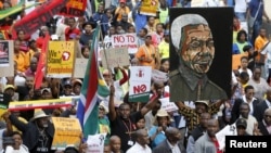 FILE - Demonstrators carry placards during a march against xenophobia in downtown Johannesburg, April 23, 2015.