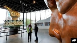 The original torch and flame, and full scale face model (R) are displayed in the new Statue of Liberty Museum, on Liberty Island, in New York, May 13, 2019.