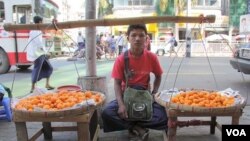 Seorang anak laki-laki menjual buah di tepi jalan di Rangoon, Burma (5/12).
