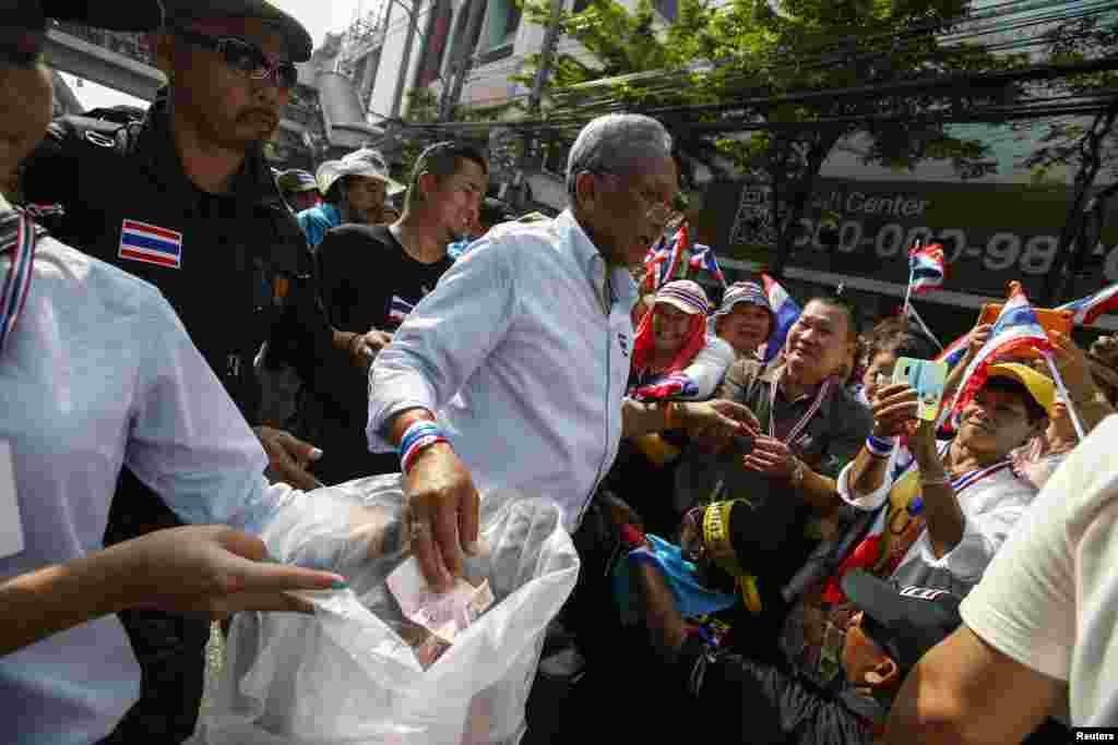 Anti-government protest leader Suthep Thaugsuban receives donations from supporters as he marches in Bangkok, Jan. 7, 2014.