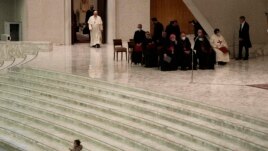 Pope Francis arrives for his weekly general audience as a child plays on the steps of the Paul VI Hall, at the Vatican, Wednesday, Dec. 22, 2