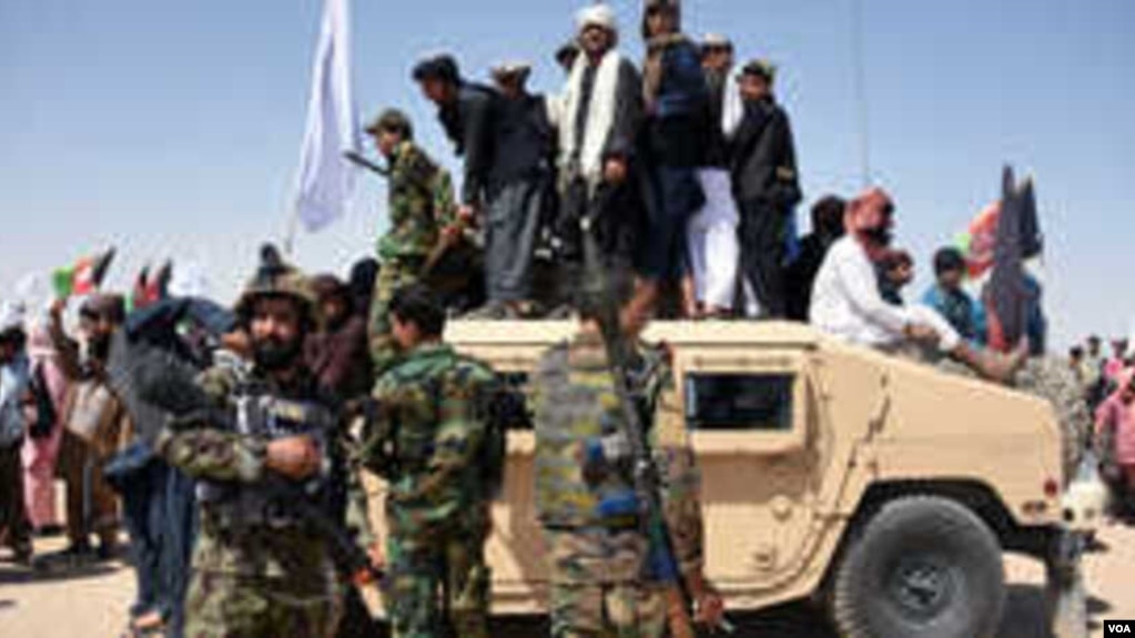 阿富汗塔利班武装分子和居民站在阿富汗国民军（ANA）的一辆装甲悍马车上，庆祝开斋节第三天在坎大哈省迈万德地区的停火。（2018年6月17日）(photo:VOA)
